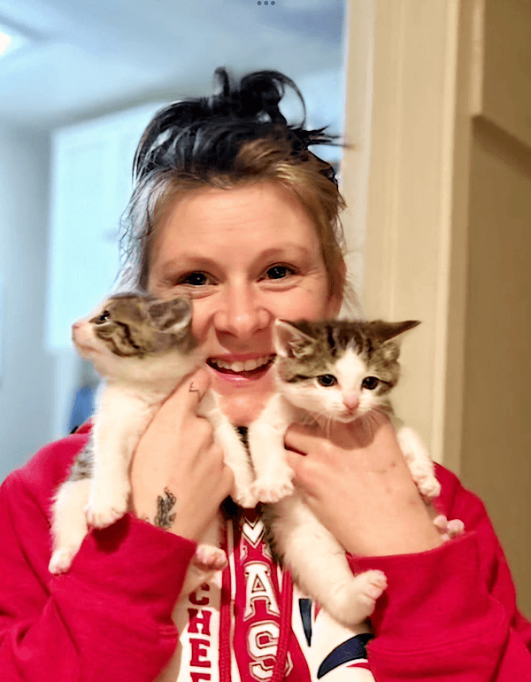 Two happy adopted kittens with their adopter
